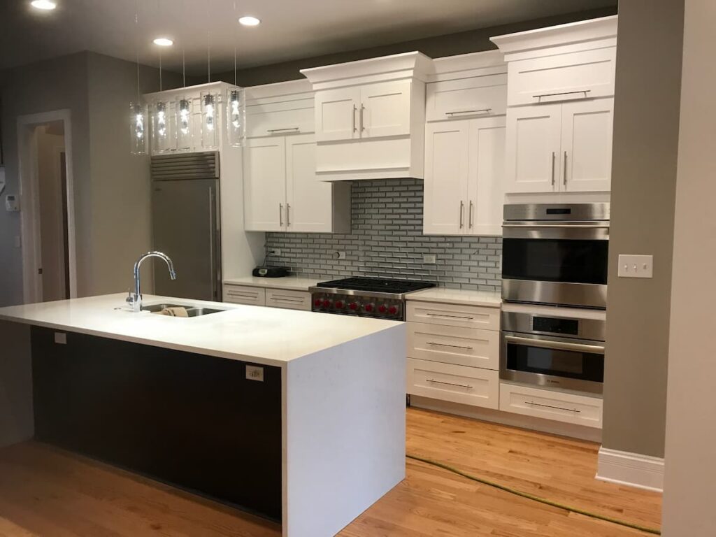 White shaker kitchen cabinets with island and double oven in Chicago home