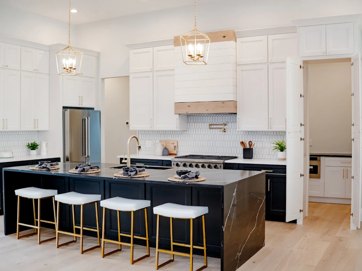 White shaker kitchen cabinets with black countertops and stainless appliances