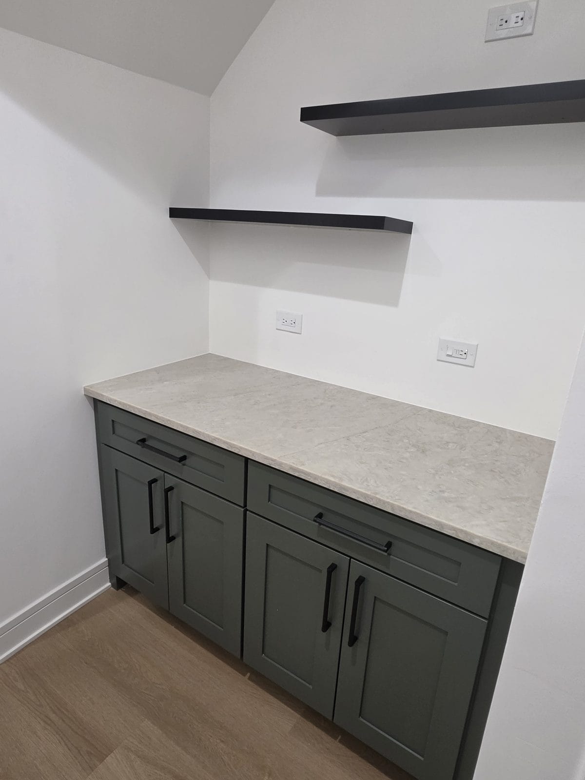 Sage green shaker kitchen cabinets with black hardware and quartz countertops in an Englewood, Chicago home