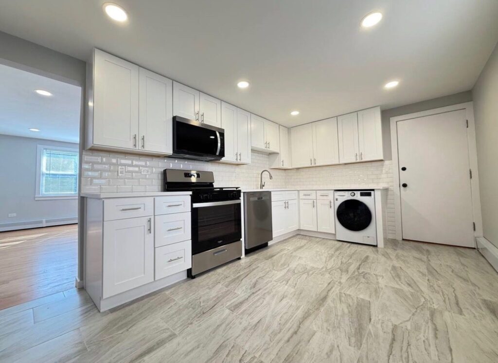 Timeless Shaker White rental kitchen with brushed nickel pulls, white subway tile and a front-load washer, Dunning, Chicago
