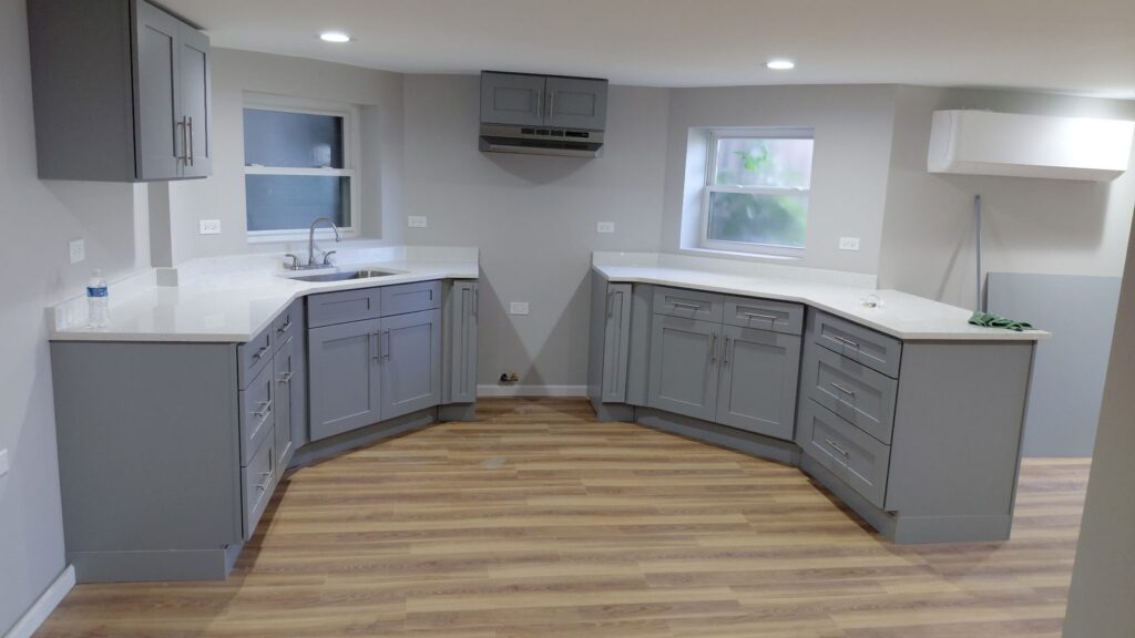 Gray shaker kitchen cabinets with white quartz countertops in an angled layout, Humboldt Park, Chicago