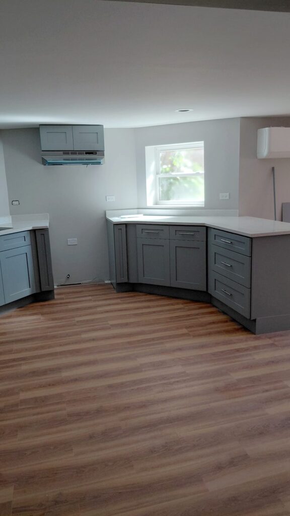 Angled run of gray shaker drawers and cabinets with white quartz top, Humboldt Park, Chicago
