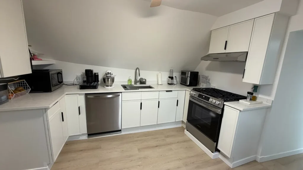Slim Shaker Dove White kitchen cabinets with black bar pulls in a Chicago apartment kitchen