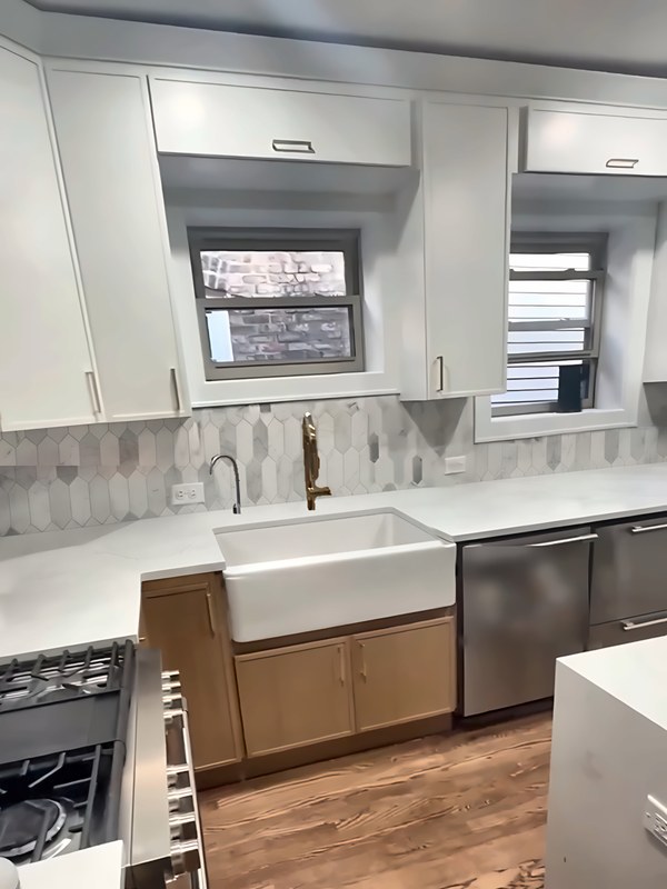 Sink wall of a two-tone Chicago kitchen: Dove White slim shaker uppers to the ceiling over white-oak slim shaker base cabinets and a farmhouse sink.